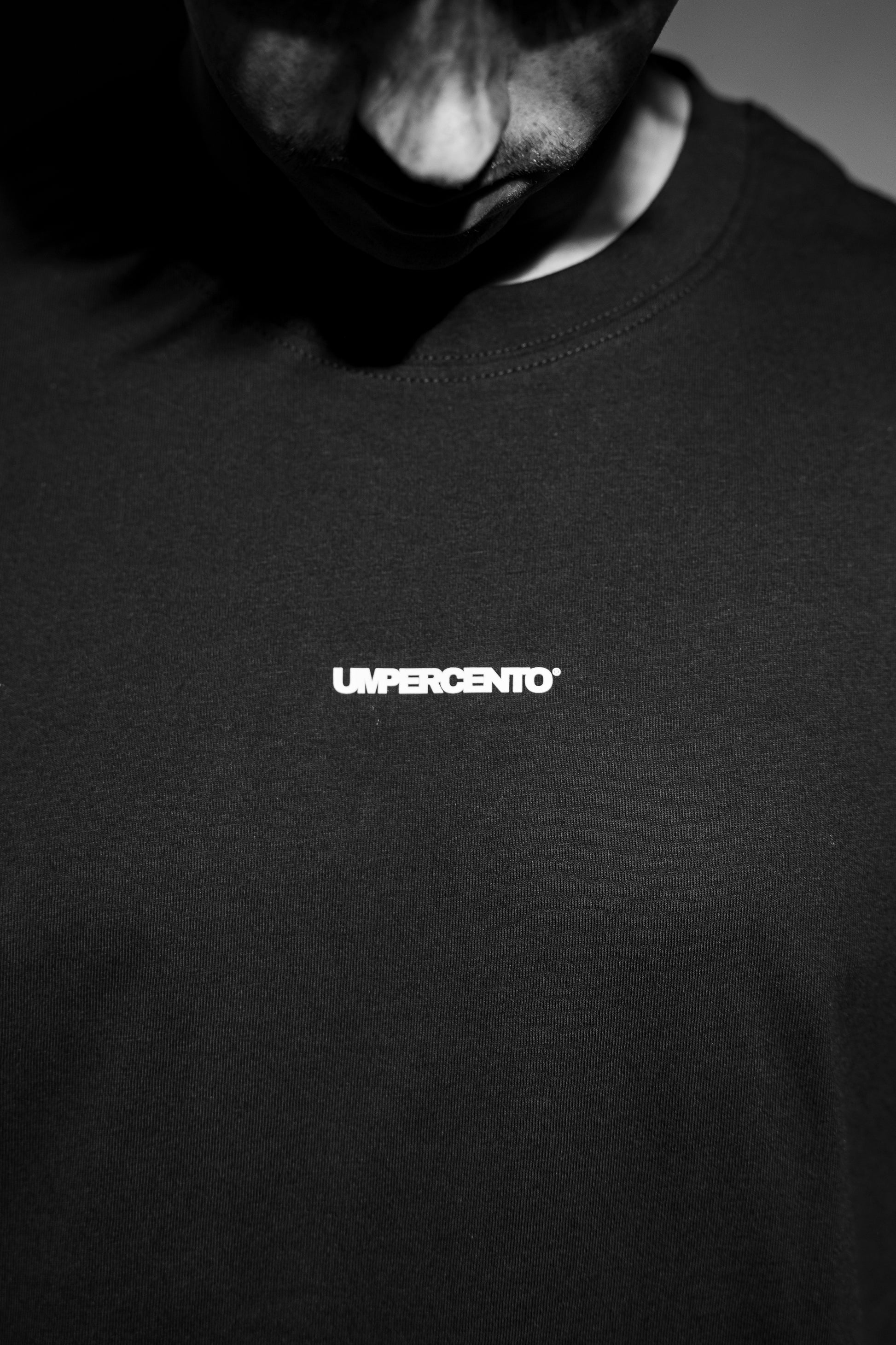 Chest close-up of oversized T-shirt — small “umpercento” logo detail